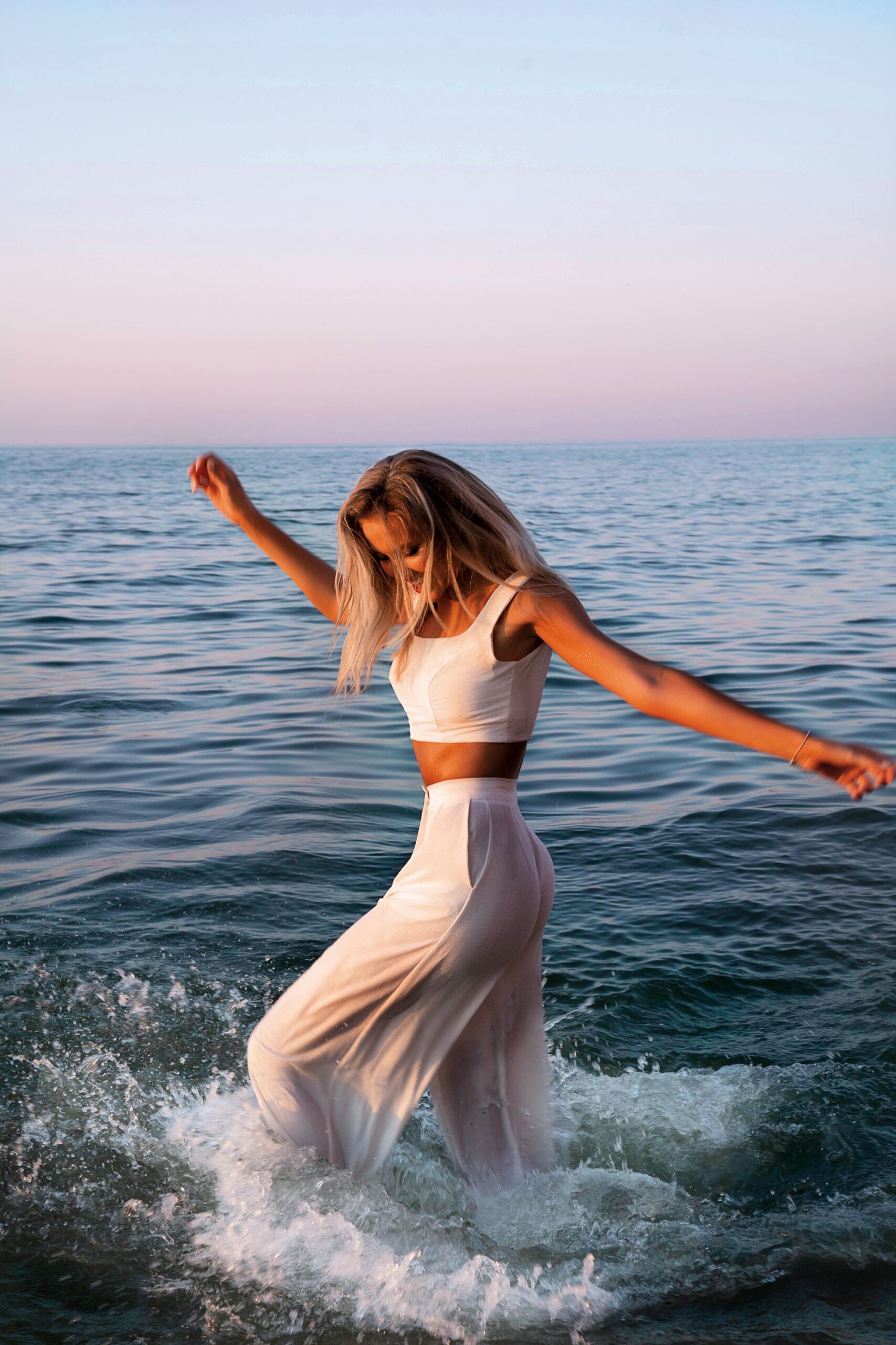 sunset-woman-white-top-pants-wet-bohemian-outfit
