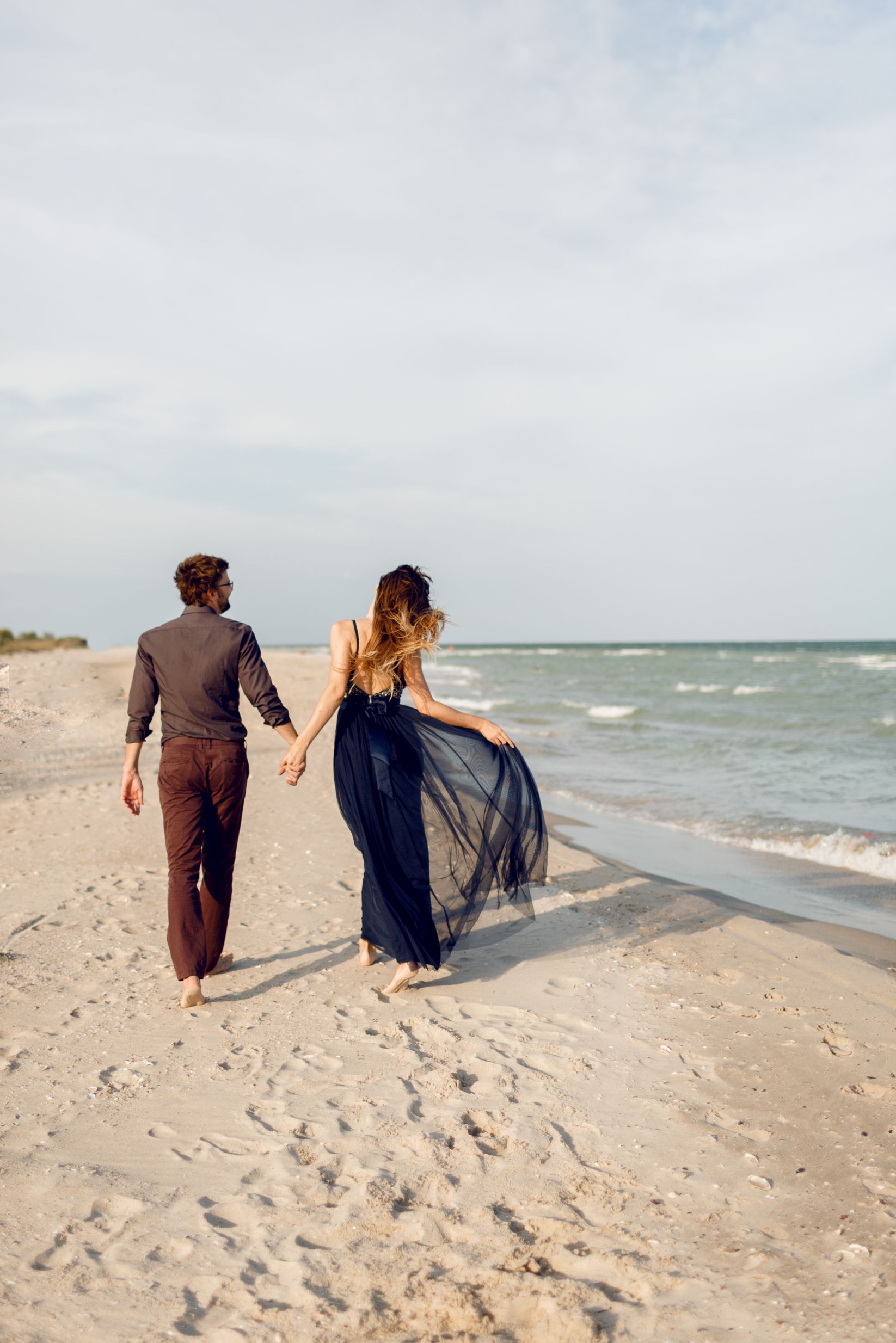 view-from-back-elegant-couple-love-walking-along-beach-romantic-moments-white-sand-ocean-waves-tropical-vacation-full-height